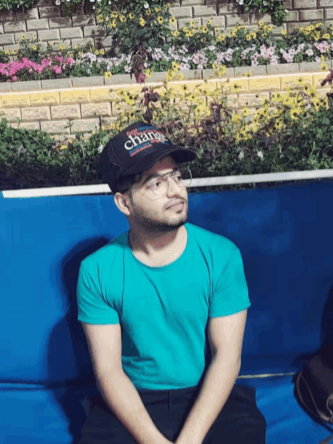 a man wearing a blue shirt and a black hat that says super change