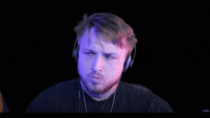 a man with a beard wearing headphones is making a funny face .