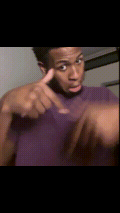 a man wearing a purple shirt is pointing at the camera