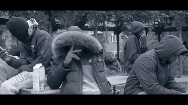 a black and white photo of a group of men wearing hoods and masks