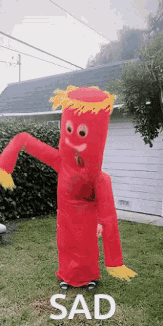 a person in a red inflatable costume with the word sad on the bottom