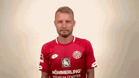 a man is wearing a red shirt that says kommerling premium fenster