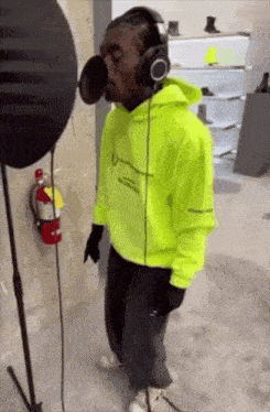 a man wearing headphones is singing into a microphone .