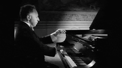 a black and white photo of a man playing the piano