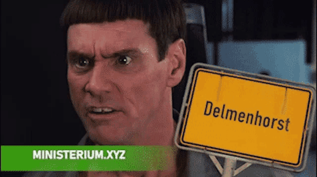 a man holding a sign that says delmenhorst on it