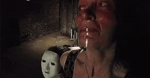 a woman is crying and holding a mask in her hand .