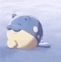 a blue and yellow whale is floating on top of a body of water .