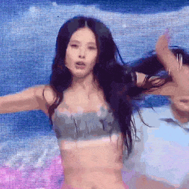 a woman in a bikini top is dancing with a man