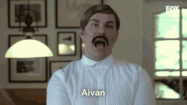 a man with a mustache is wearing a white shirt with the name aivan on it