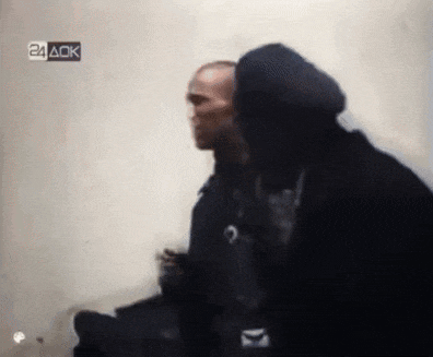 two men are standing next to each other in front of a wall with a 24 ack logo on it .