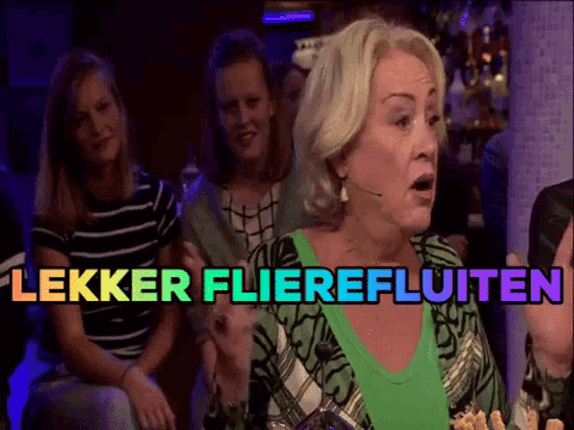 a woman in a green shirt stands in front of a sign that says lekker flierefluuten