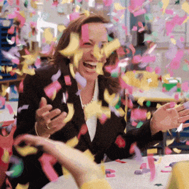a woman is surrounded by confetti and laughing