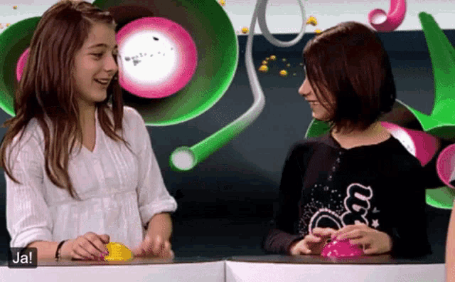 two girls are playing a game and the word ja is on the bottom left