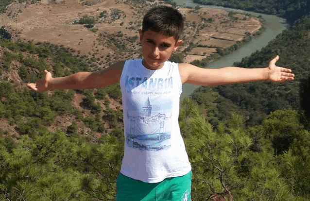 a young boy wearing a tank top that says istanbul on it
