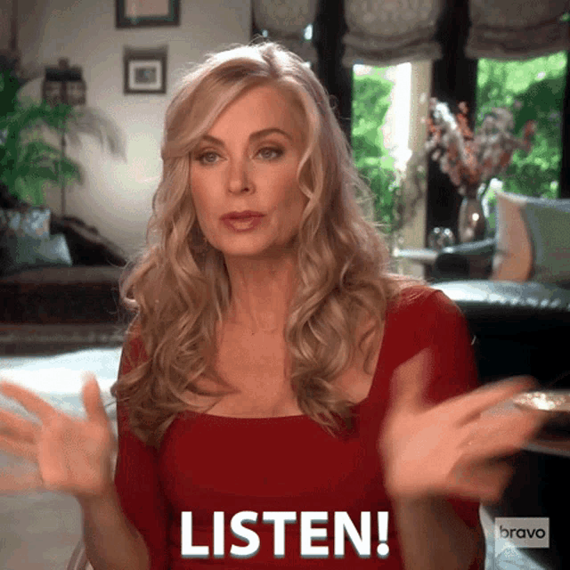 a woman in a red dress is saying listen with her hands outstretched