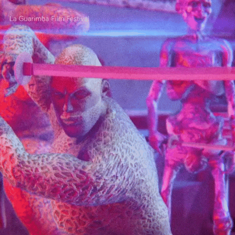 a man in a leopard print costume is holding a sword in front of two skeletons at la guarimba film festival