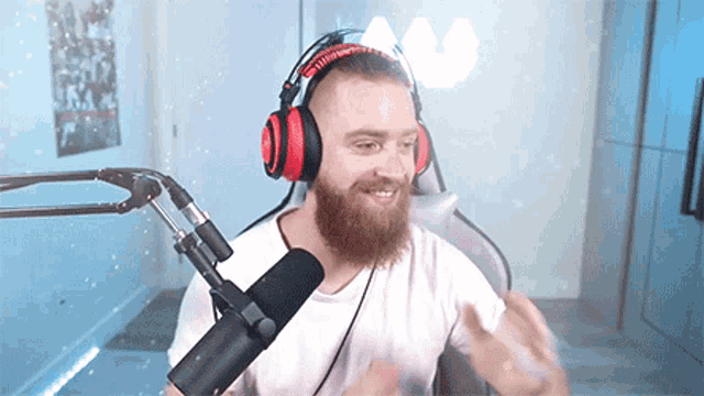 a man with a beard is wearing headphones and a microphone .