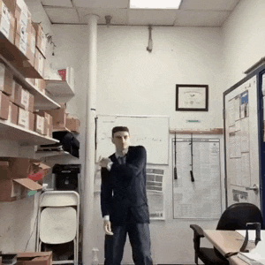 a man in a suit stands in front of a white board that says " first aid " on it