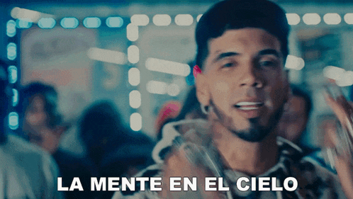 a man says la mente en el cielo in front of a crowd of people