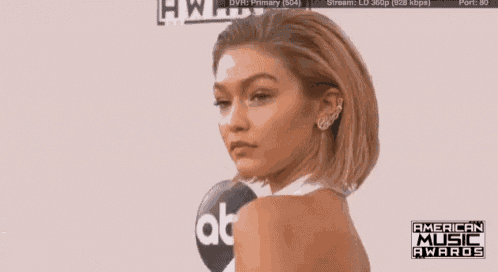 a naked woman is standing in front of an american music awards banner