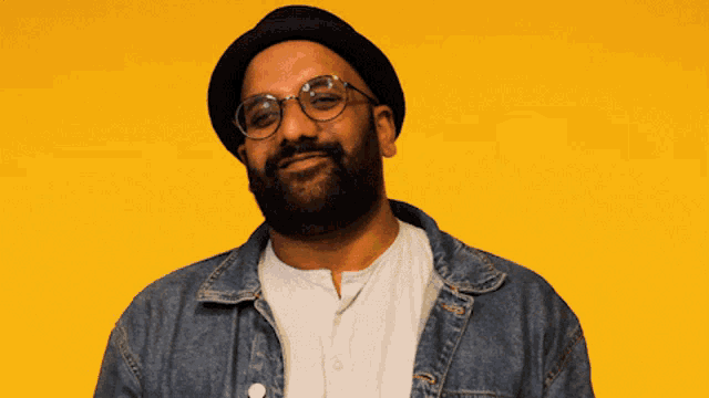 a man with glasses and a beard wearing a hat