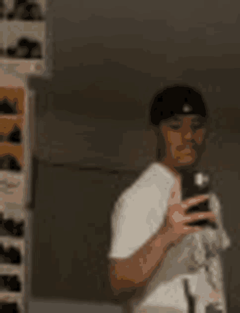 a man is taking a selfie in front of a mirror with his cell phone .