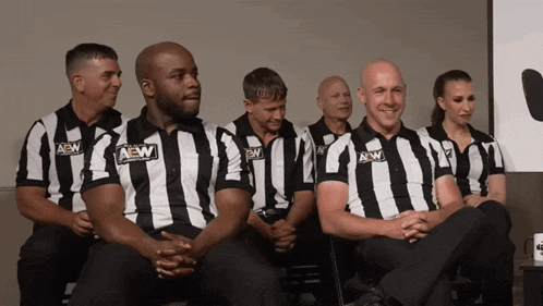 a group of men and women wearing aew shirts