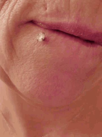 a close up of a woman 's face with a piercing in her ear