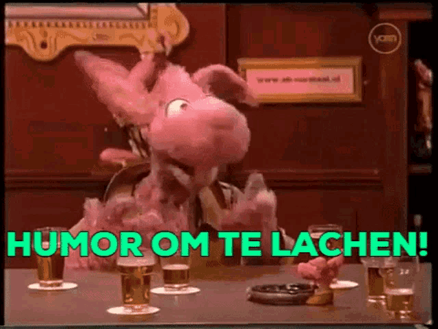 a pink stuffed animal is sitting at a table with glasses of beer and the words humor om te lacheni