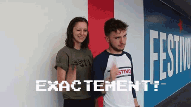 a man and a woman are standing in front of a wall that says " exactement "