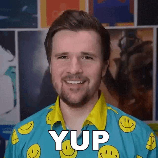 a man wearing a blue shirt with smiley faces and the word yup written on it