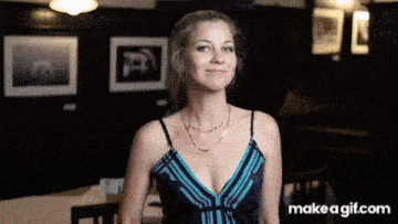 a woman in a blue and black dress is smiling in front of a make a gif.com advertisement