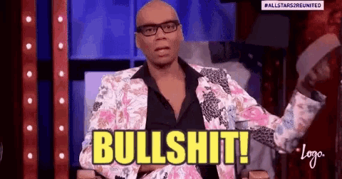 a man in a floral suit and glasses is sitting in a chair and says bullshit .