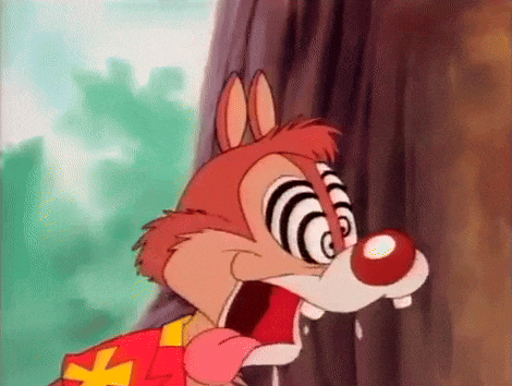 a cartoon squirrel with hypnotic eyes is standing next to a tree .
