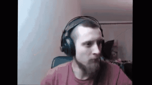 a man with a beard wearing headphones is sitting in a chair .