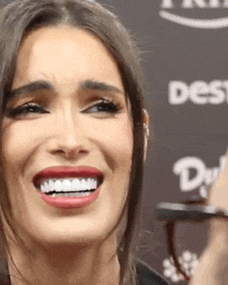 a close up of a woman 's face with a large smile