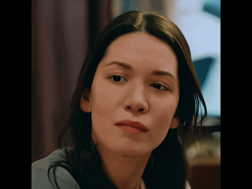 a close up of a woman 's face with a sad look on her face