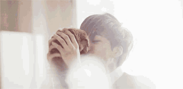 a young man is holding a small puppy in his hands .