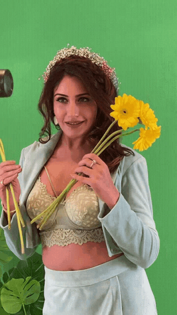 a woman with a flower crown on her head is holding flowers