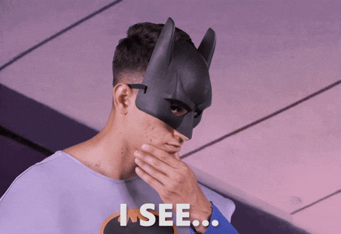 a man wearing a batman mask is covering his mouth with his hand and the words i see below him