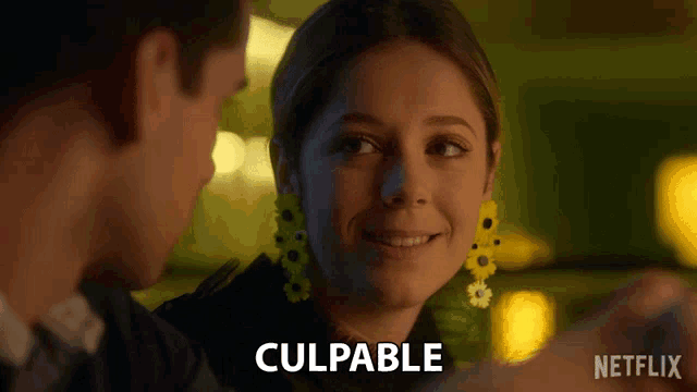 a woman wearing a pair of yellow sunflower earrings looks at a man with the word culpable written on the bottom