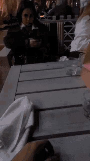 a candle sits on a table in front of a bag