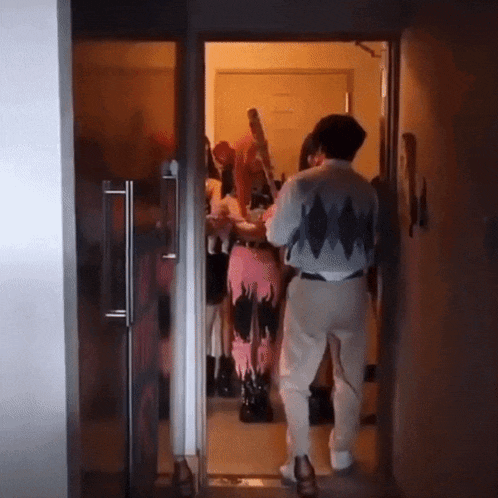 a man standing in a hallway with a woman in a costume
