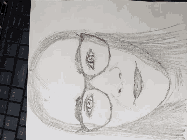 a pencil drawing of a woman wearing glasses sits on top of a keyboard