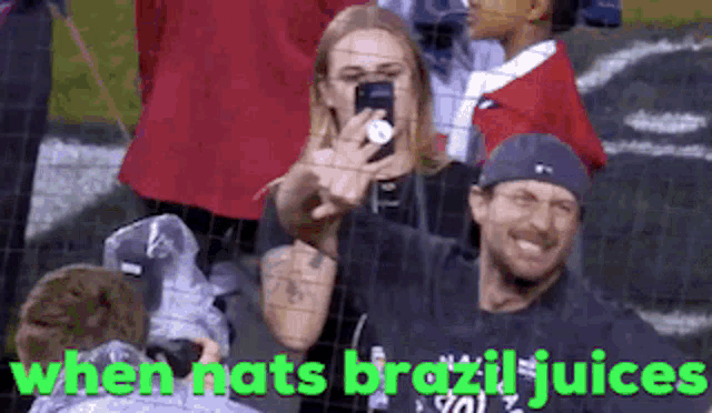a man taking a picture of a woman behind a fence with the words when nats brazil juices below him
