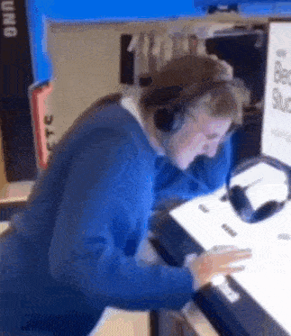 a man wearing headphones is sitting in front of a computer screen .
