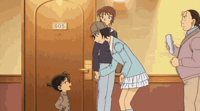 a group of people standing in front of a door labeled 605