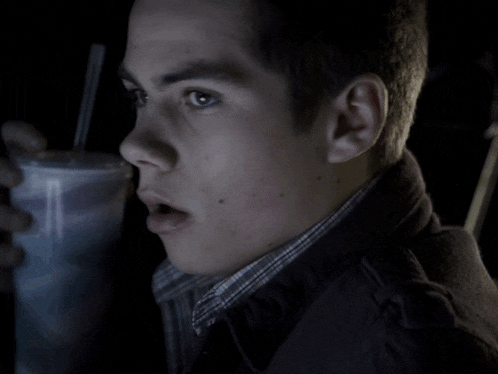 a close up of a person 's face with a straw in their hand