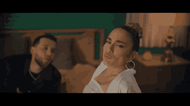 a man and a woman are standing next to each other on a bed