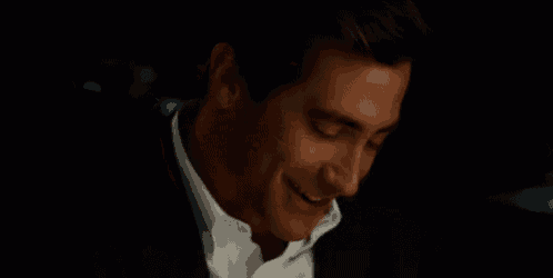 a close up of a man in a suit and white shirt smiling .